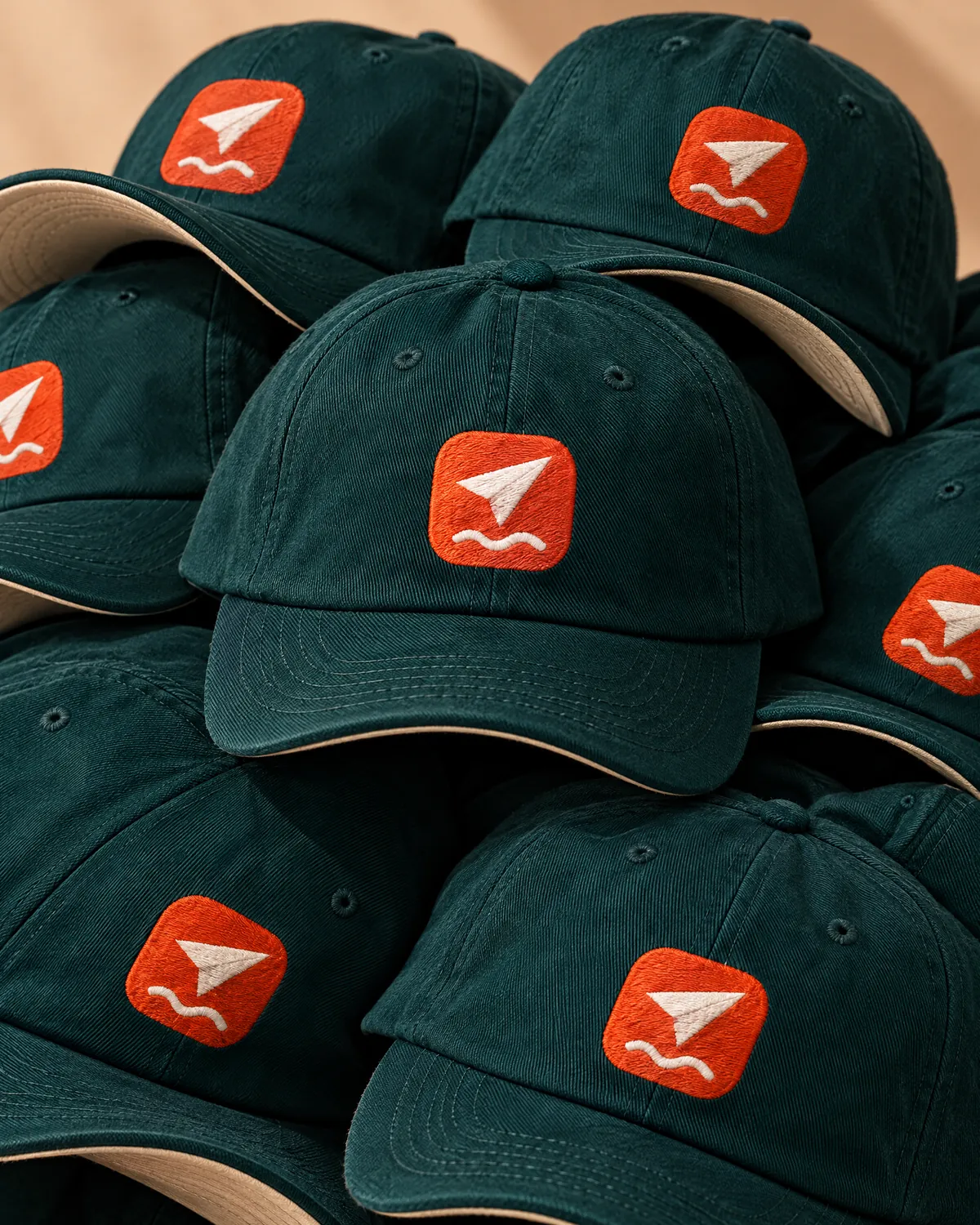 A pile of teal caps embroidered with the FerrySend icon